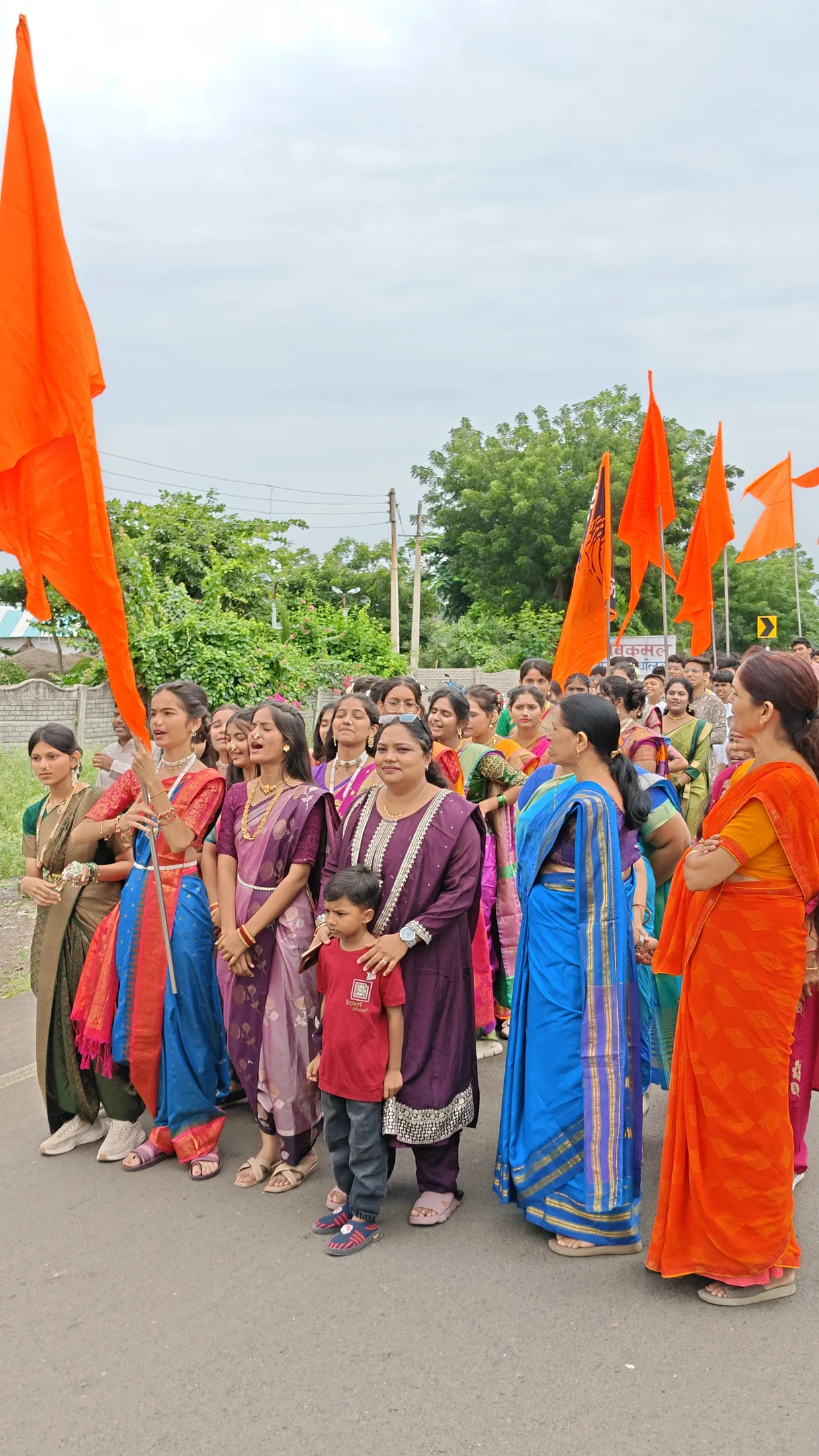 Students, families and educators gathered with saffron flags during Ganpati arrival