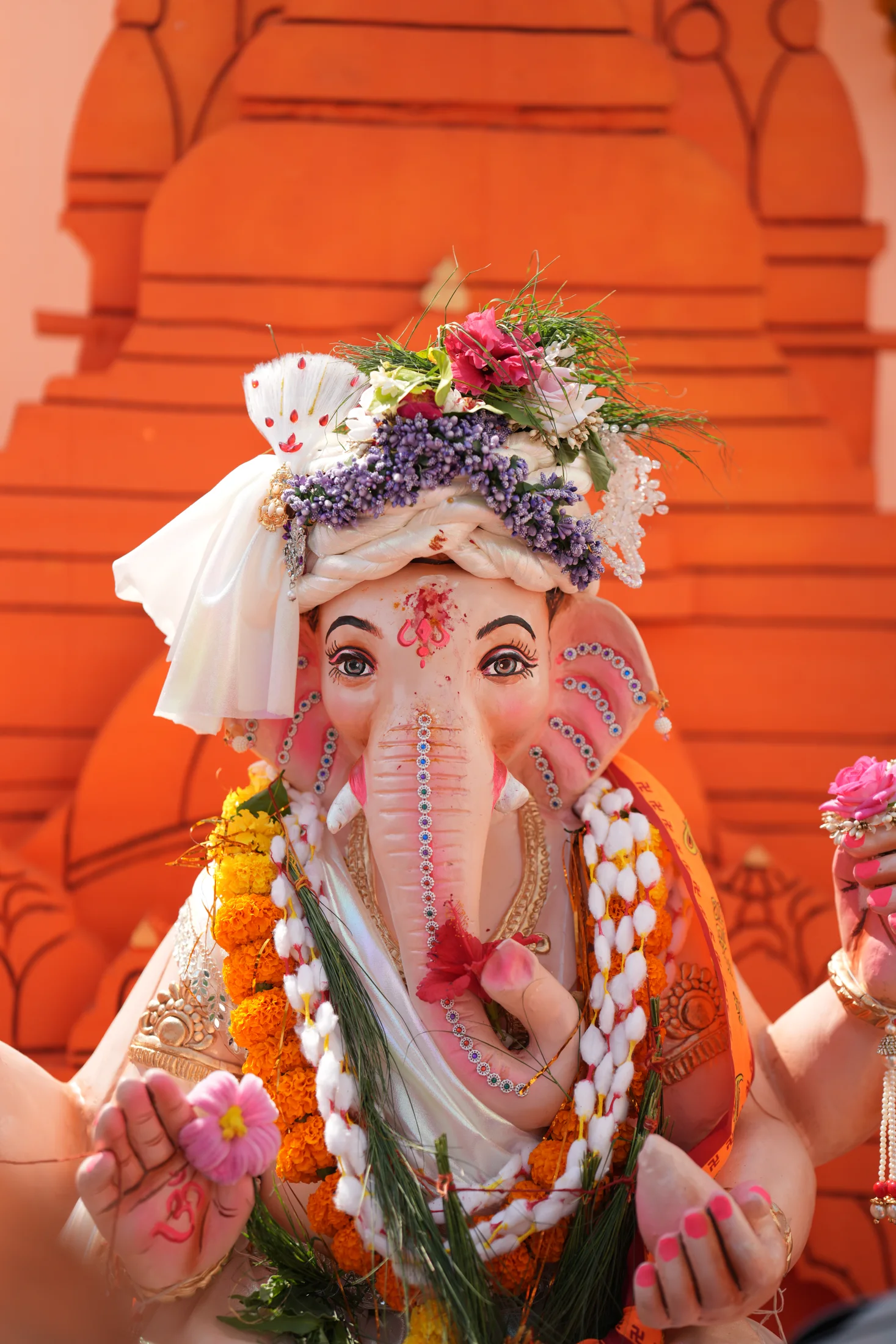 Close view of Lord Ganesha idol adorned with flowers and festive ornaments