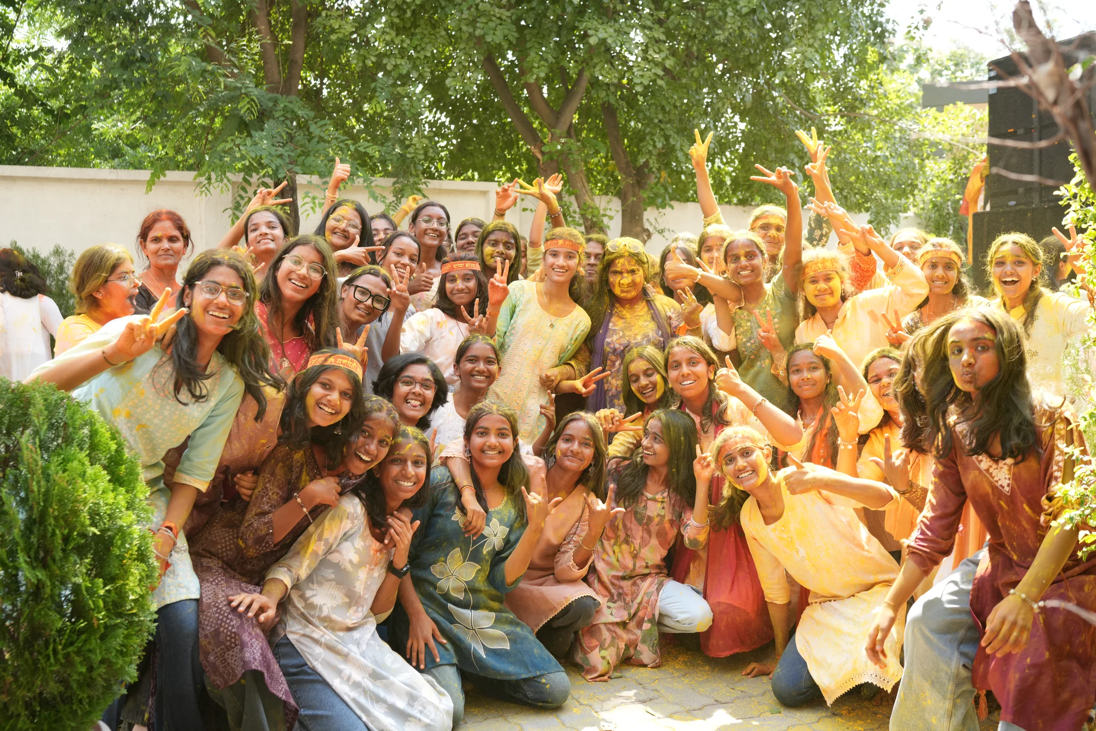Large group of students smiling with gulal during Ganesha Week