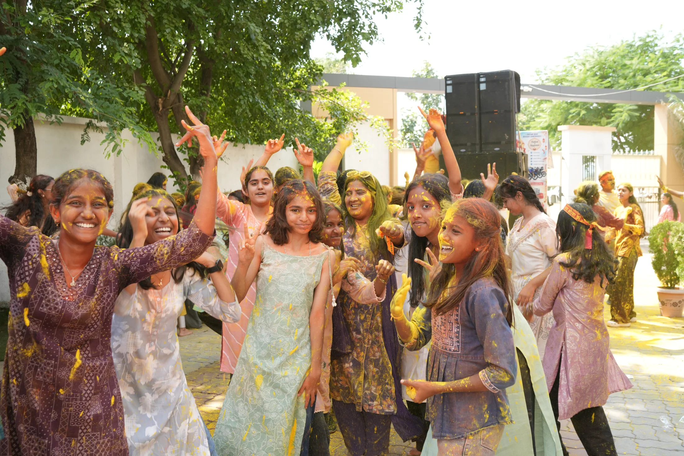 Students smiling and dancing with gulal