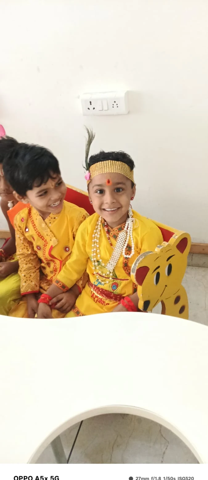 Young student smiling in yellow Krishna attire