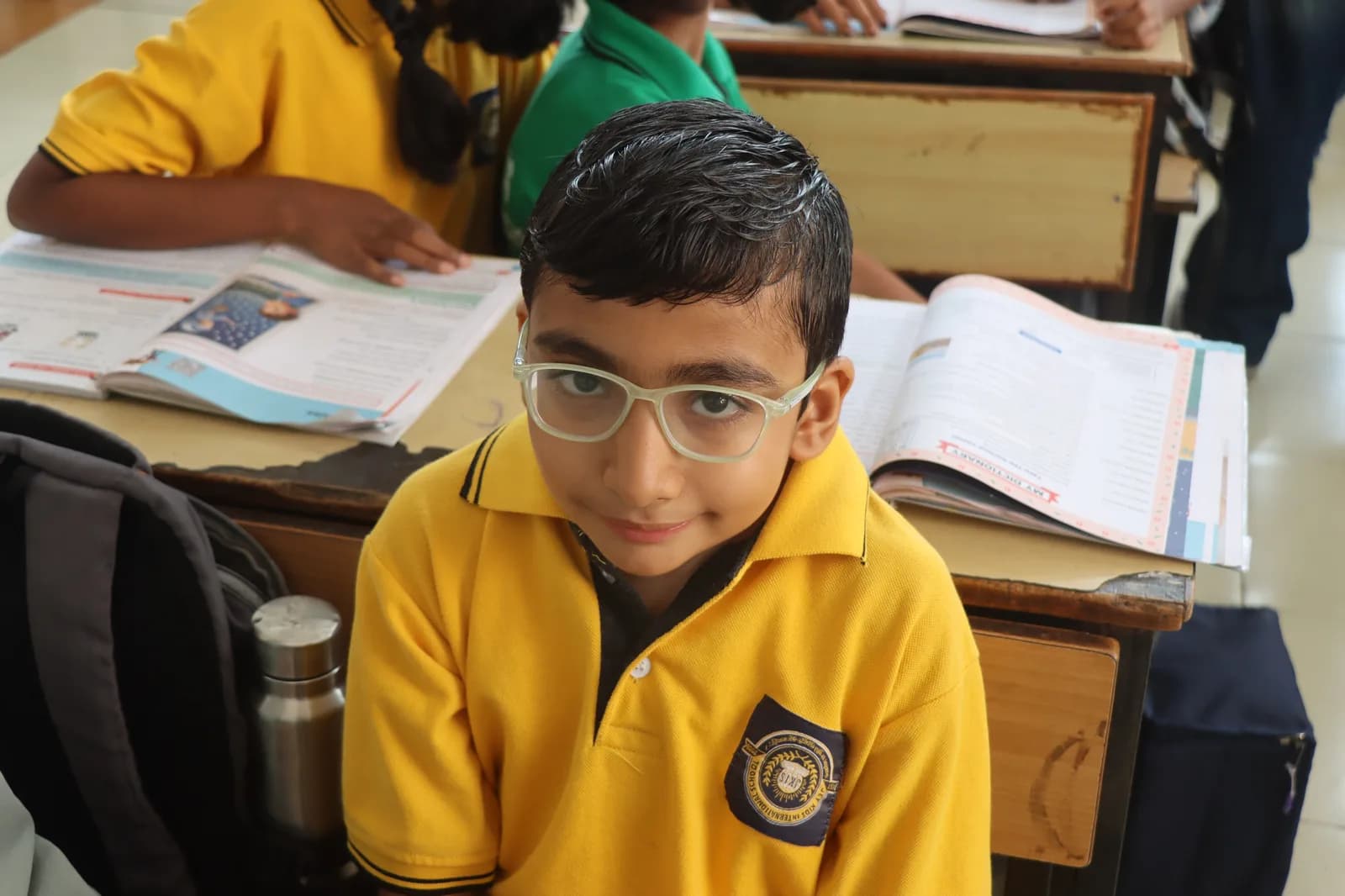 Primary school students collaborating at their desks in a well-ventilated classroom