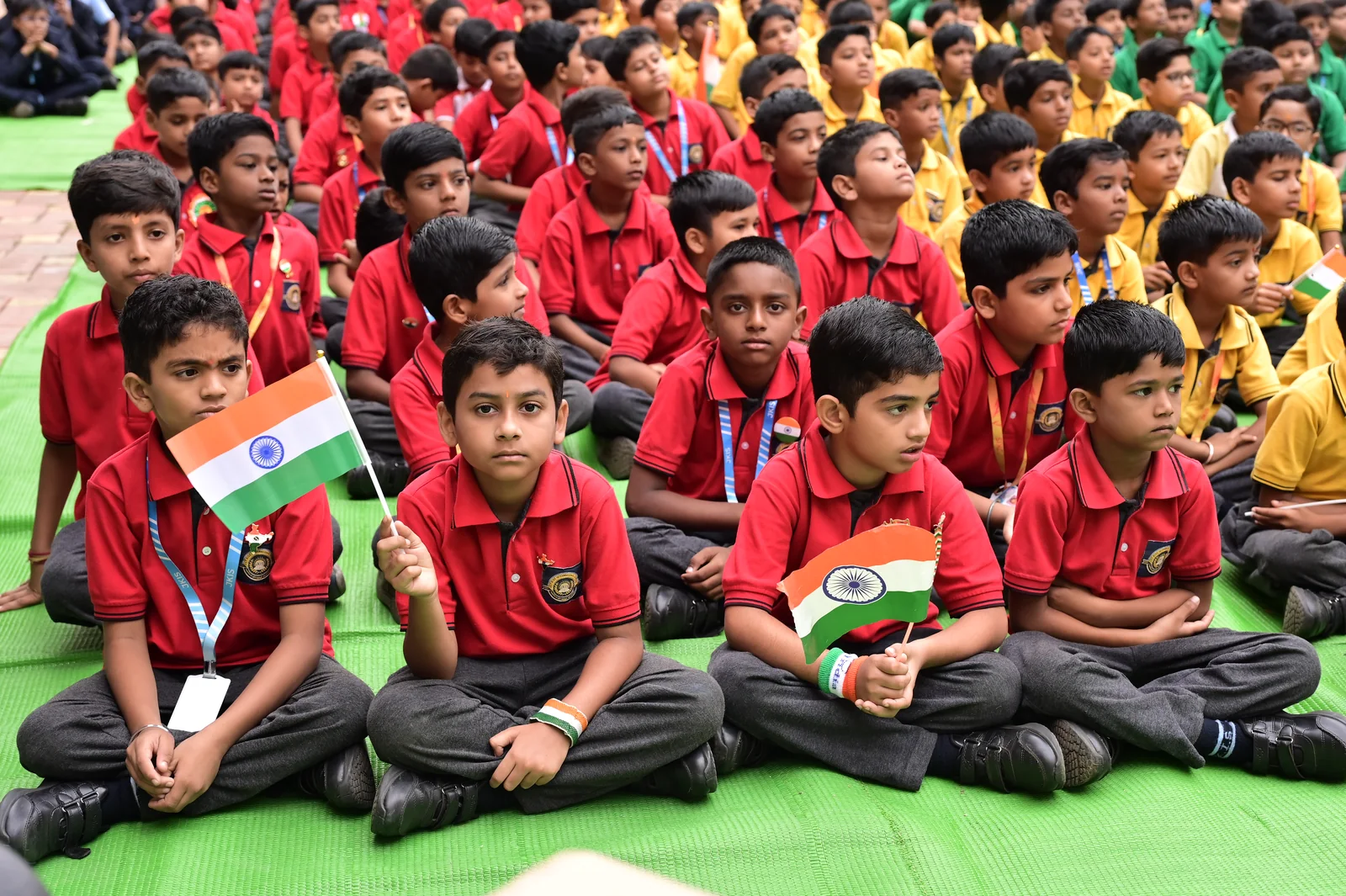Young primary scholars holding tricolour flags